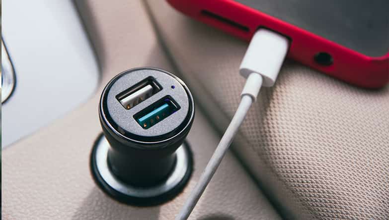 Telefoon ligt aan de car charger op te laden, Lightning kabel zit in de smartphone.