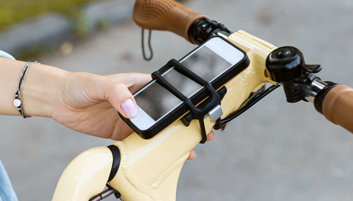 Telefoon zit vast aan een telefoonhouder op de fiets, zo kun je je navigatie veilig blijven volgen.