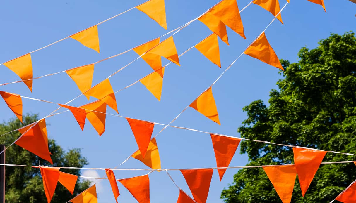 Straat hangt vol met oranje vlaggetjes om de sfeer voor het EK voetbal 2024 te creëren.