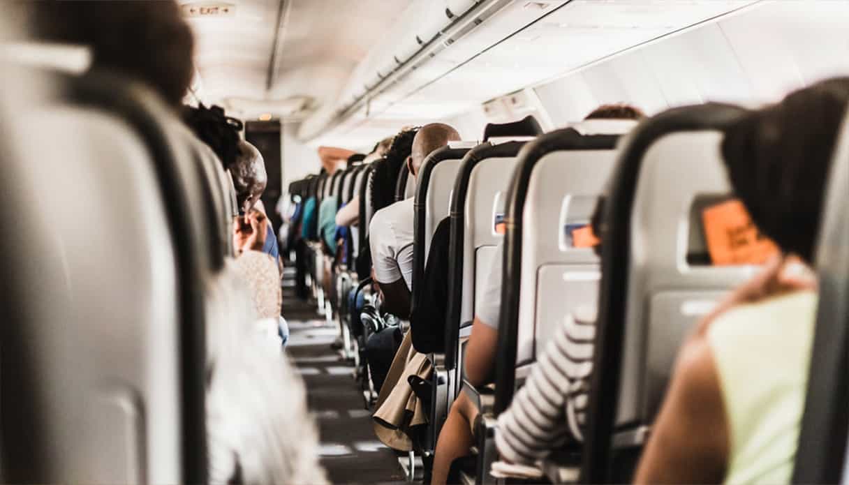 Passagiers zitten op hun stoel in het vliegtuig, onderweg naar een bestemming.