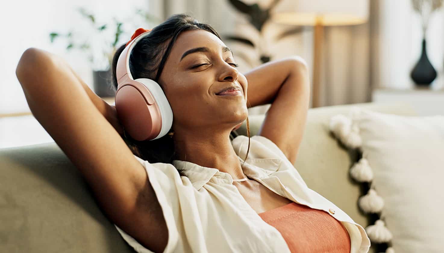 Vrouw loopt over straat terwijl ze tot rust komt met haar noise cancelling koptelefoon.