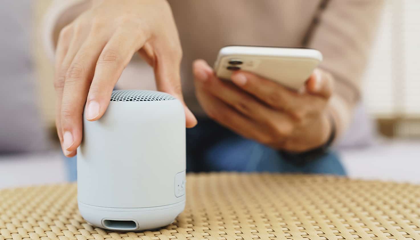 Bluetooth speaker staat op de salontafel en wordt gekoppeld met de telefoon.