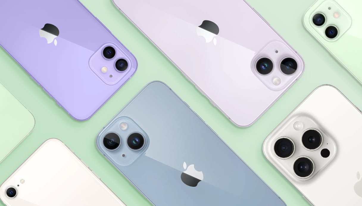 Verschillende kleuren en modellen iPhones op een groene achtergrond. Ze liggen met de achterkant naar boven, dus je ziet de lenzen en Apple-logo's.