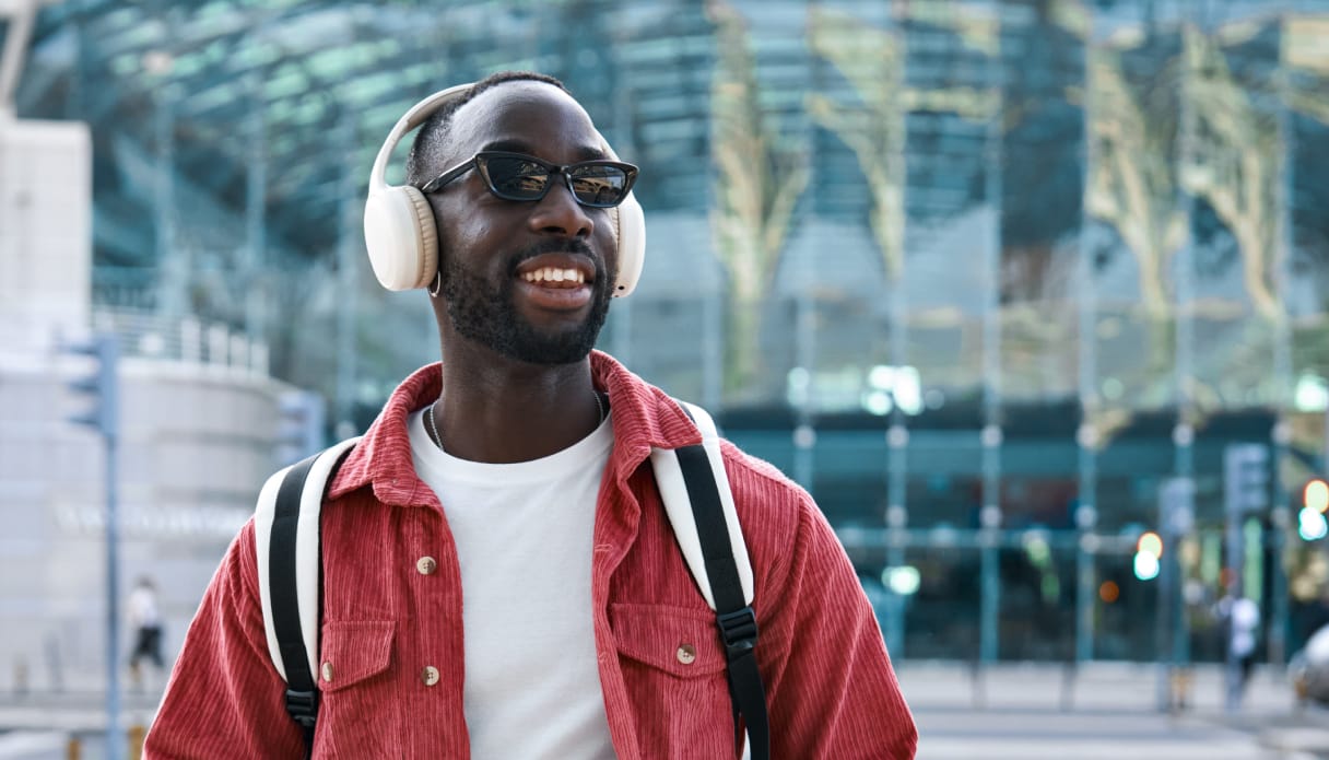 Een man is onderweg en luistert met zijn koptelefoon naar muziek.