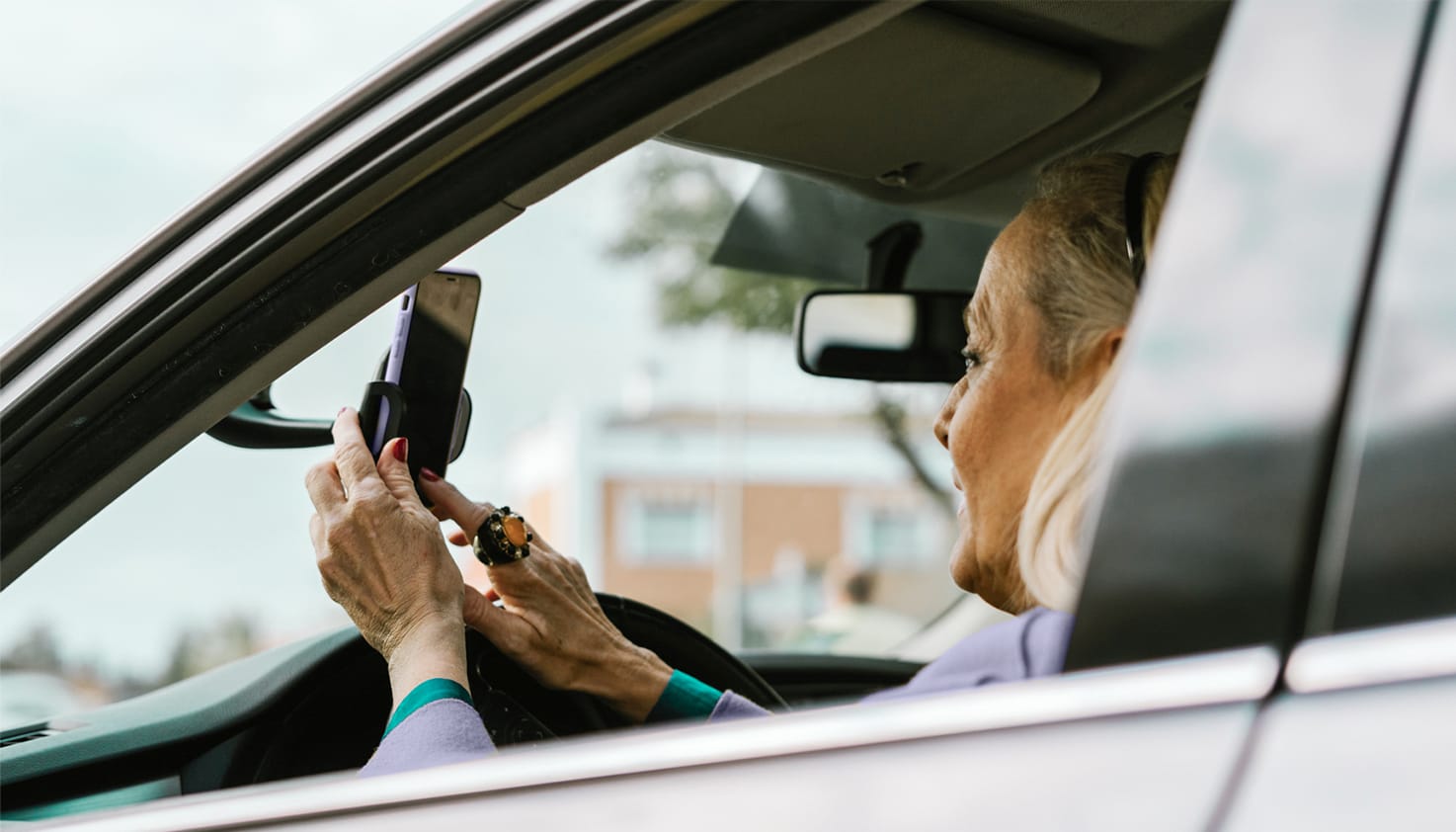 Vrouw gebruikt haar telefoon in een telefoonhouder