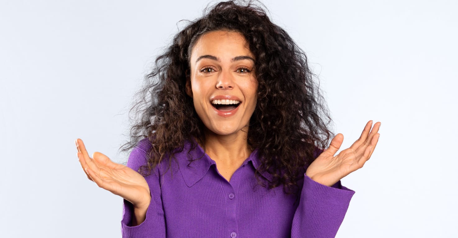 een vrouw kijkt vragend in de camera met haar handen omhoog