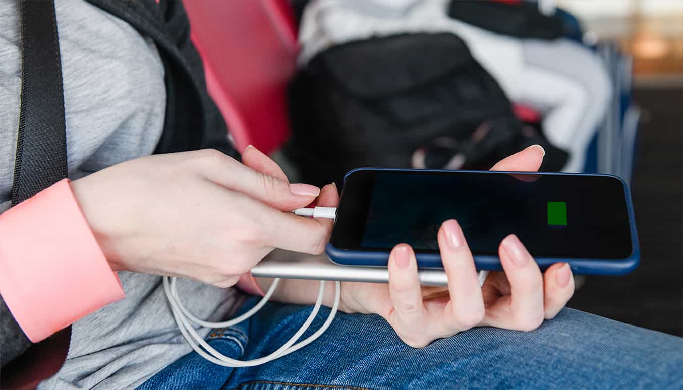 Knaloranje achtergrond met een opvallende groene kleur powerbank en matchende telefoon.